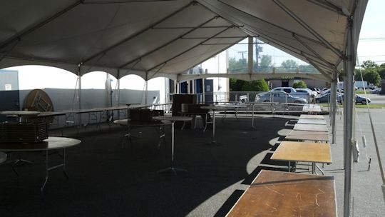 tables set up in a u unter tent