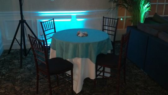 3 foot round tables with turquoise linens and fruitwood chairs