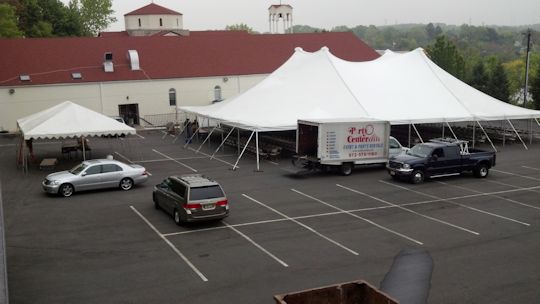 60ft x 90ft pole tent installed on asphalt with a 20ft x 30ft frame tent