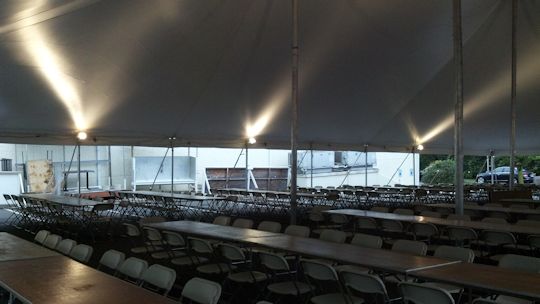 tables setup neatly under tent for event